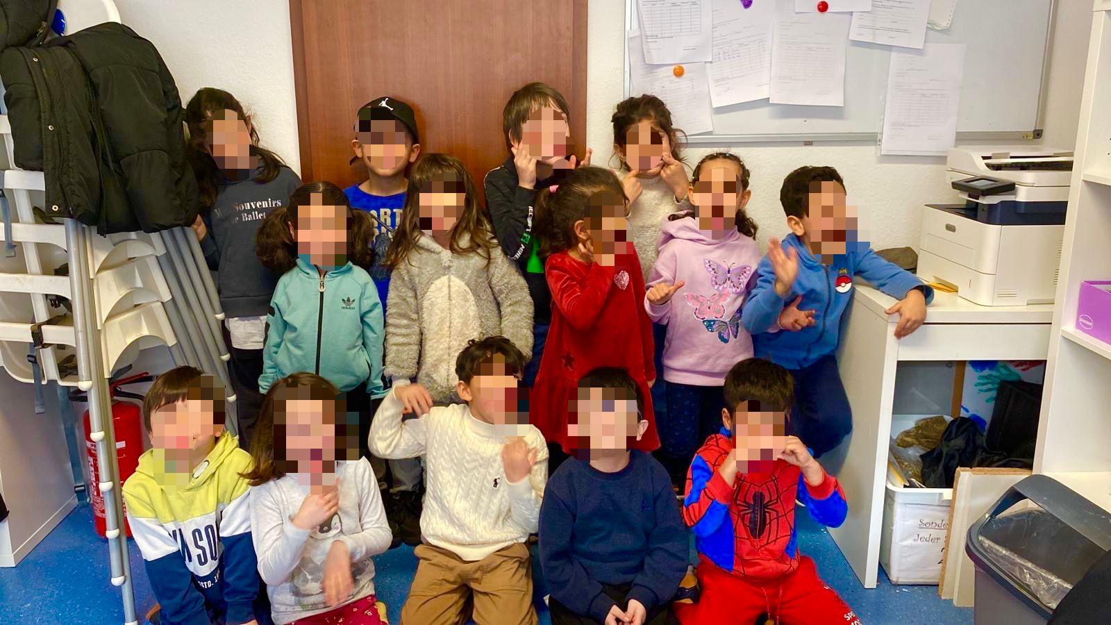 Gruppenfoto glücklicher Schülerinnen und Schüler im Klassenraum